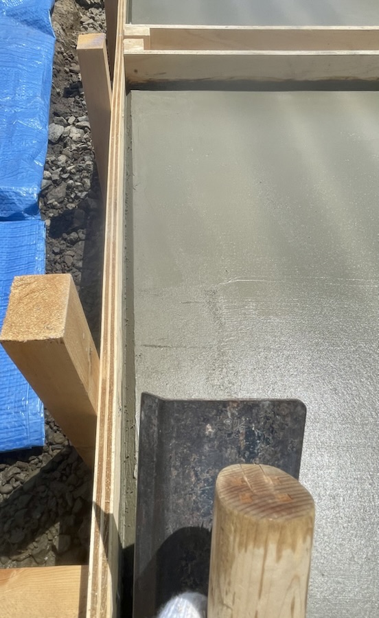 面引鏝で土間コンクリートの面を取っていきます。