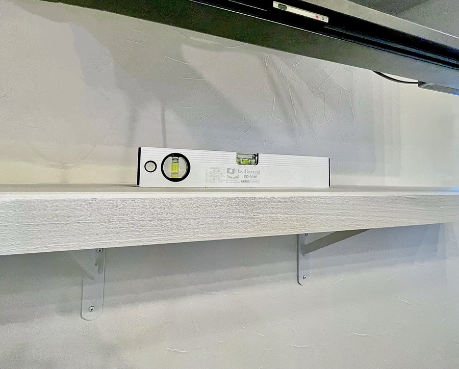 カウンターブラケットに棚板を乗せて水平を確認する