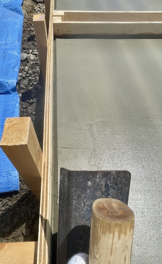 面引鏝で土間コンクリートの面を取る